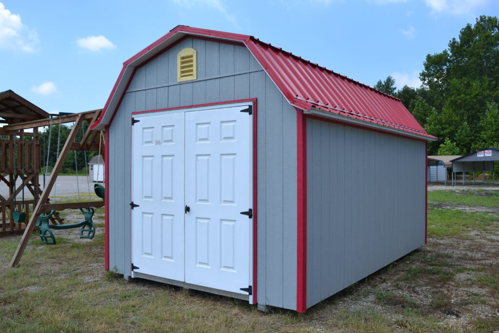 10x16 Lofted Gambrel Barn shed with gray siding, red trim, white double doors, a yellow gable vent, and red metal roofing.