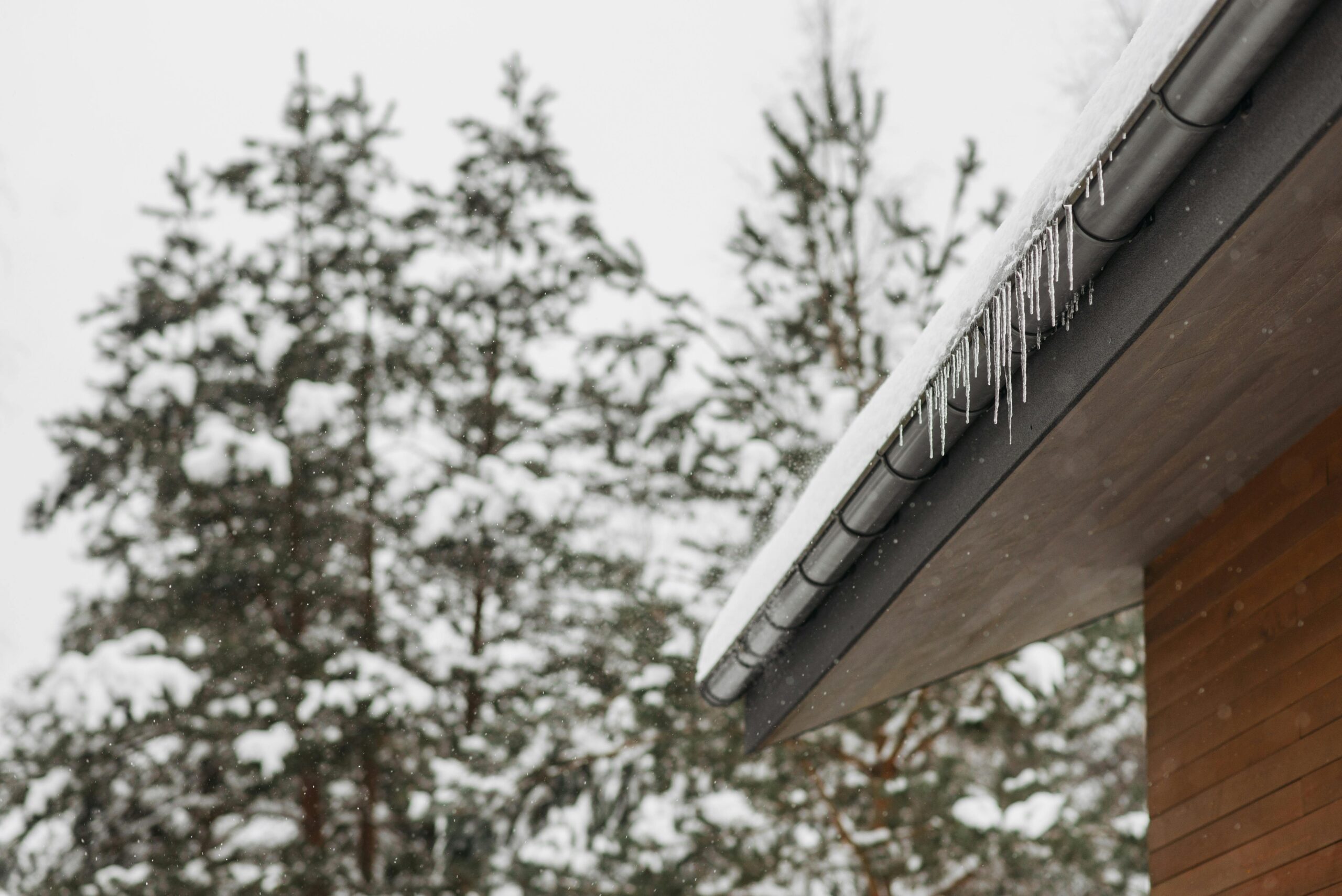 roof with snow and icicles hanging off, preparing your sheds for winter storms