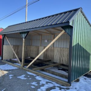 open horse barn with green siding