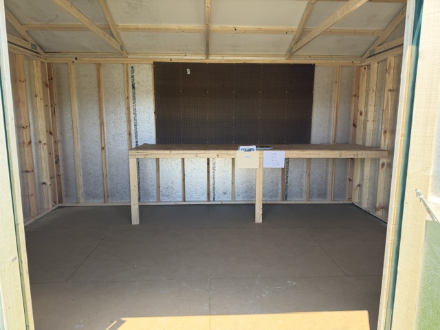inteior of a garden shed with a pegboard and workbench
