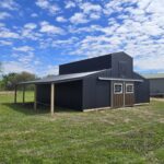 monitor horse barn with black siding and open lean