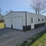 two car garage with white siding and black wainscot