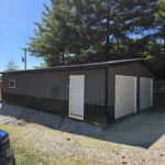 two car garage with gray siding and wainscot