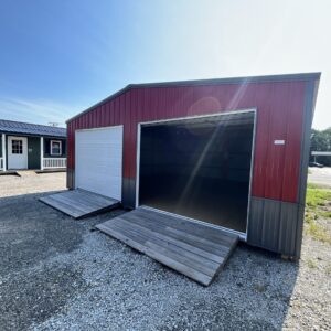24x24 two-car garage with red metal siding, dark gray wainscot, 2 white garage doors, and 2 ramps.