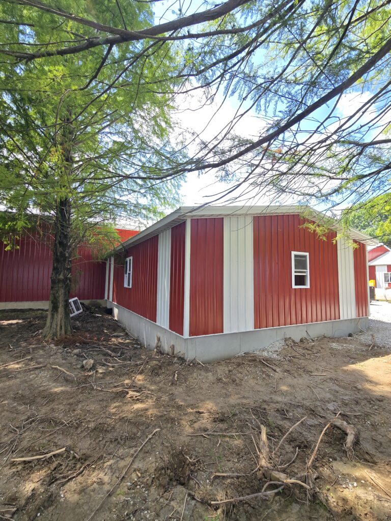 two car garage with red metal siding and white trim