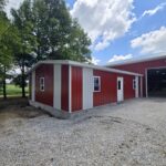 two car garage with single entry door, red siding, white trim, and windows