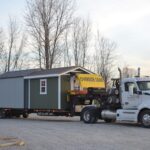 Raber delivery truck carrying three sheds