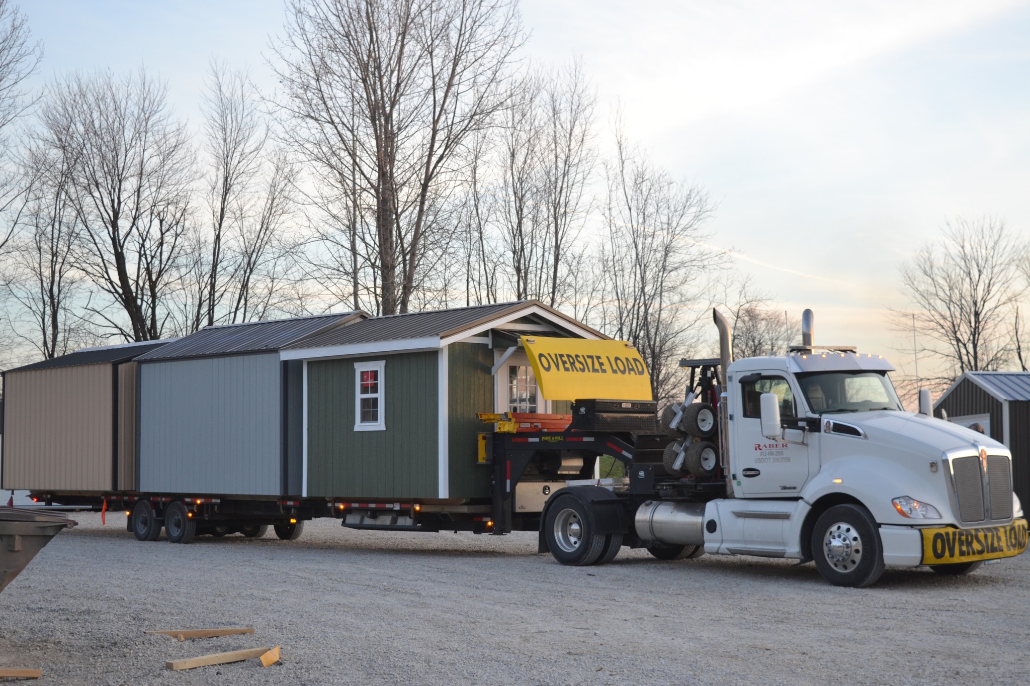Raber delivery truck carrying three sheds